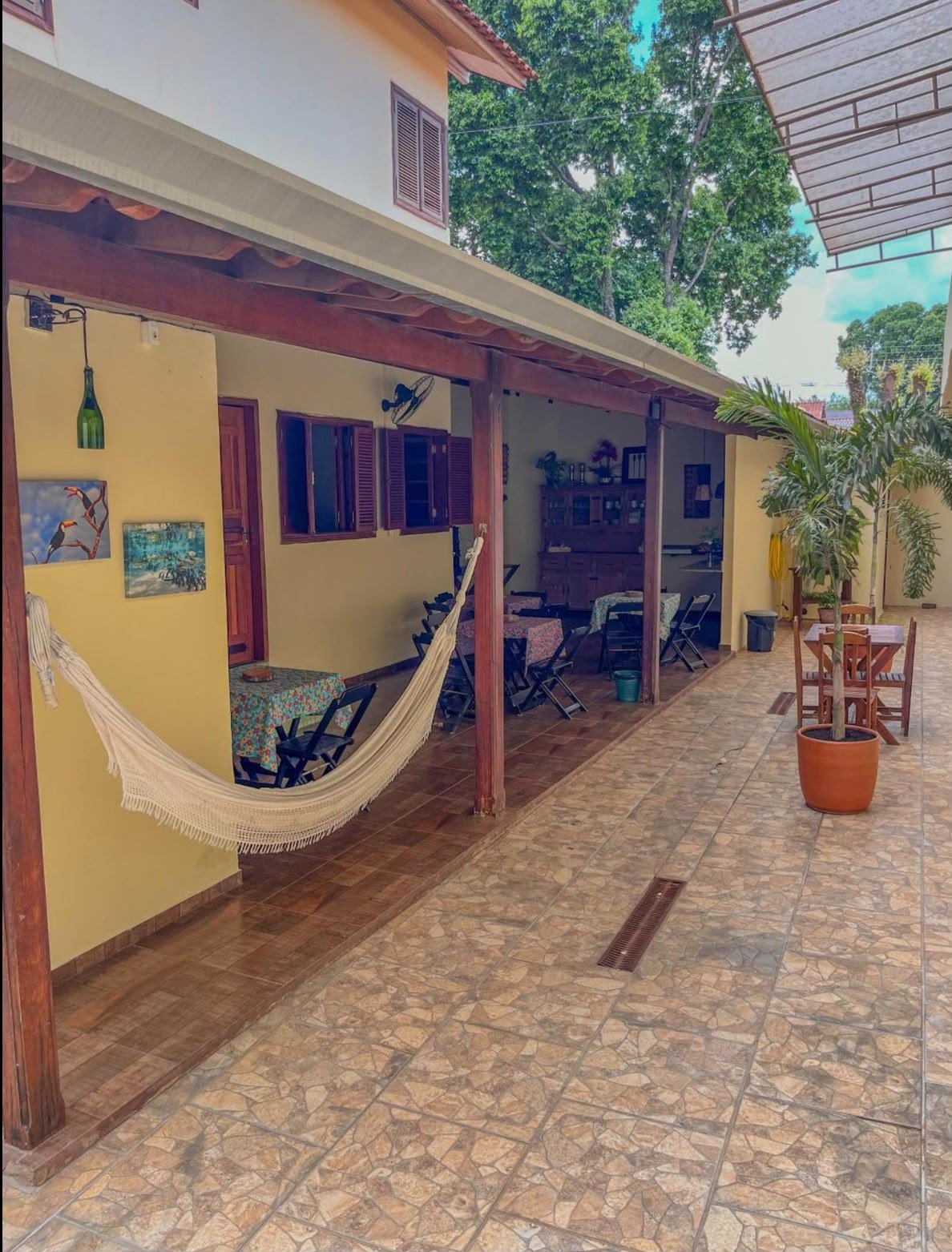 Pátio com jardim, cobertura de madeira e janelas amplas